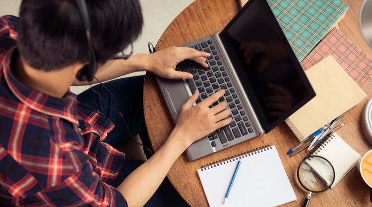 young man typing on laptop