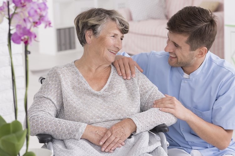 male carer taking care of elderly woman