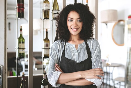 dark-skinned female restaurant manager smiling