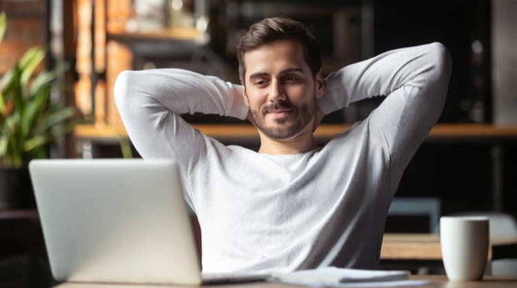 relaxed man looking at laptop screen