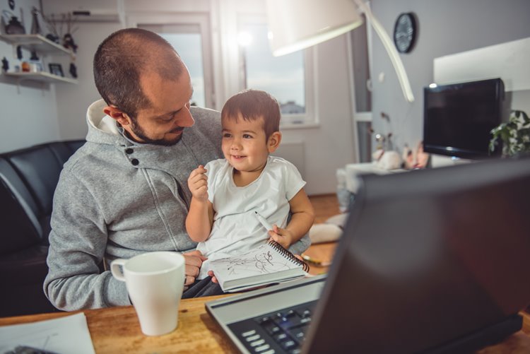 stay at home dad working in home office with son
