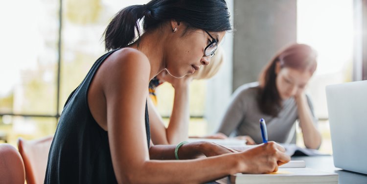 young asian woman with glasses studying