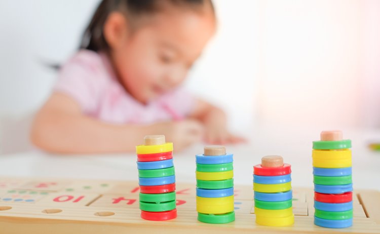 young toddler girl playing in background