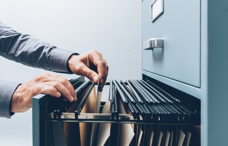 someone searching through filing cabinet