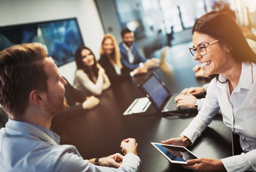 dark hair woman smiling at male colleague
