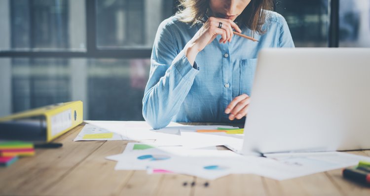 woman working with notes deep in thought