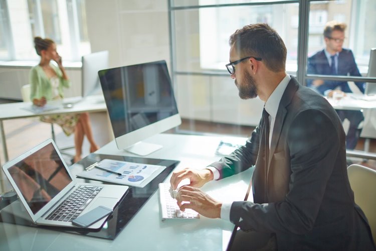 male employee working on laptop in office